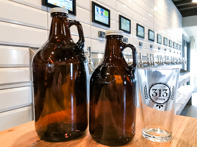 Growlers and a pint glass from 313 Taproom