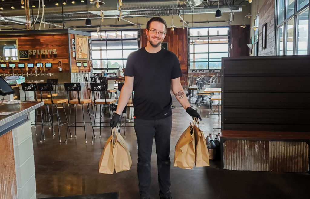 Bar Staff carrying takeout bags for home delivery