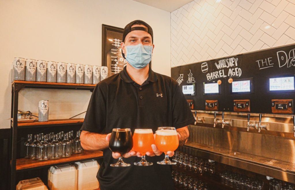 Staff member in mask at Oz. Tap House