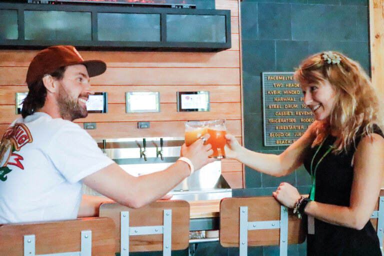 happy customers cheers in front of self-pour wall