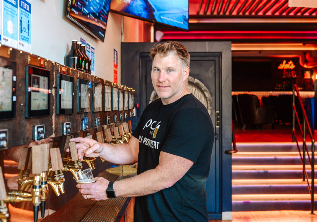 Josh pouring self-serve beer at bar