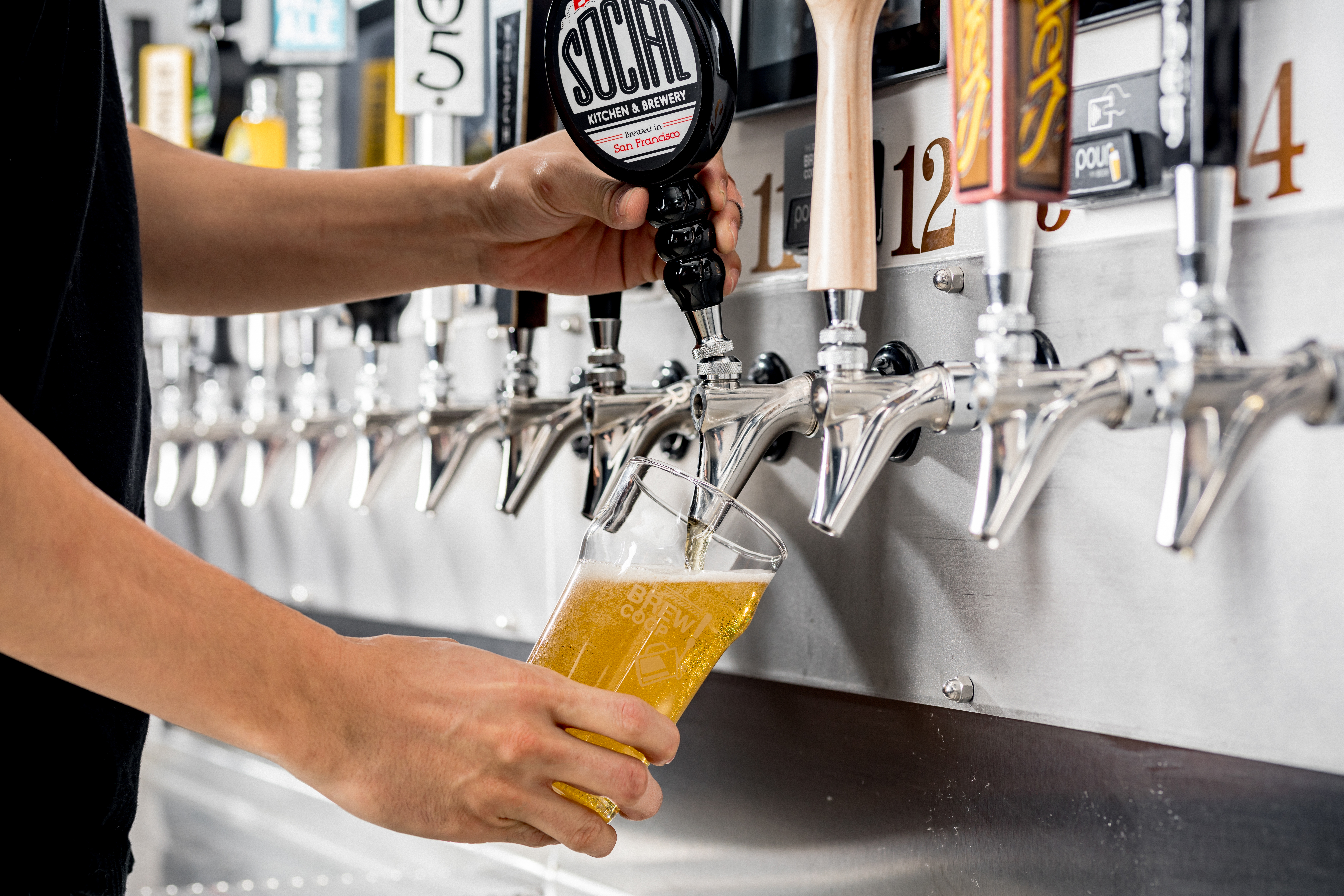 A person pouring beer from a PourMyBeer tap